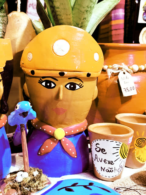 Boneca de cerâmica com lenço e chapéu