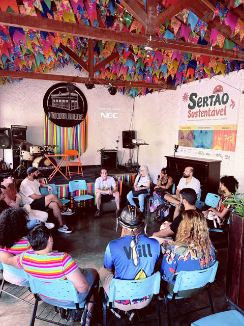 Vista ampla da sala com as pessoas em roda