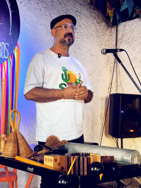 Artista explica instrumentos de percussão ao microfone