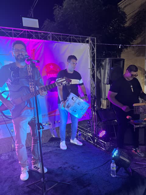 Banda no palco do Sons do Sertão com luz roxa