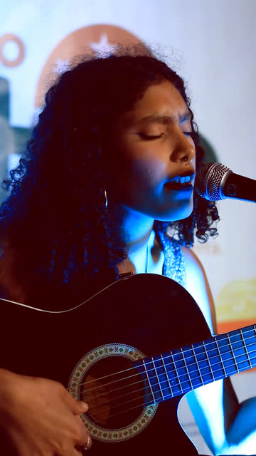 Cantora tocando violão, em close