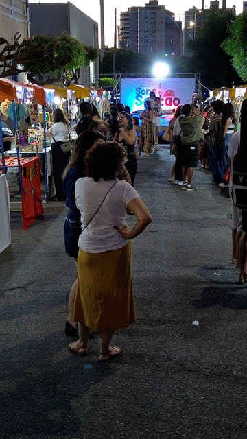 Rua da feira à noite com o palco ao fundo
