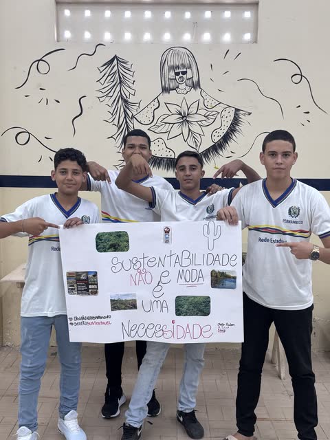 Estudantes com o cartaz Sustentabilidade não é moda, é uma necessidade