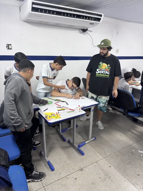 Noel, de camiseta preta do Sertão Sustentável e boné verde, acompanha estudantes na oficina