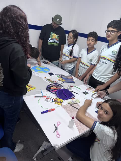 Noel com estudantes ao redor da mesa da oficina