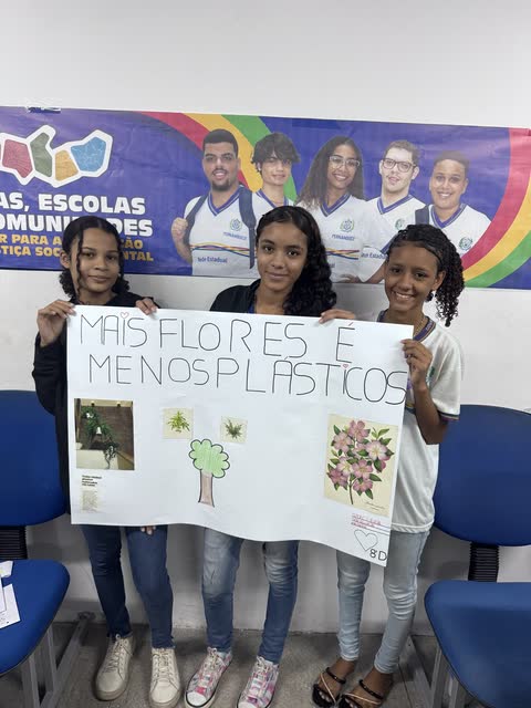 Estudantes com o cartaz Mais flores e menos plásticos