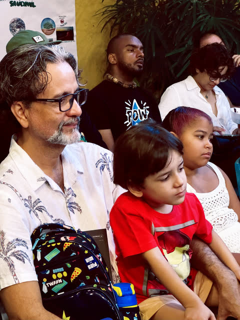 Pai e filho atentos na plateia