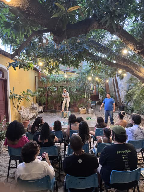 Espetáculo no pátio arborizado, com a plateia sob as luzes